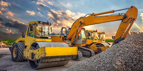 construction fleet equipment on site with rock pile